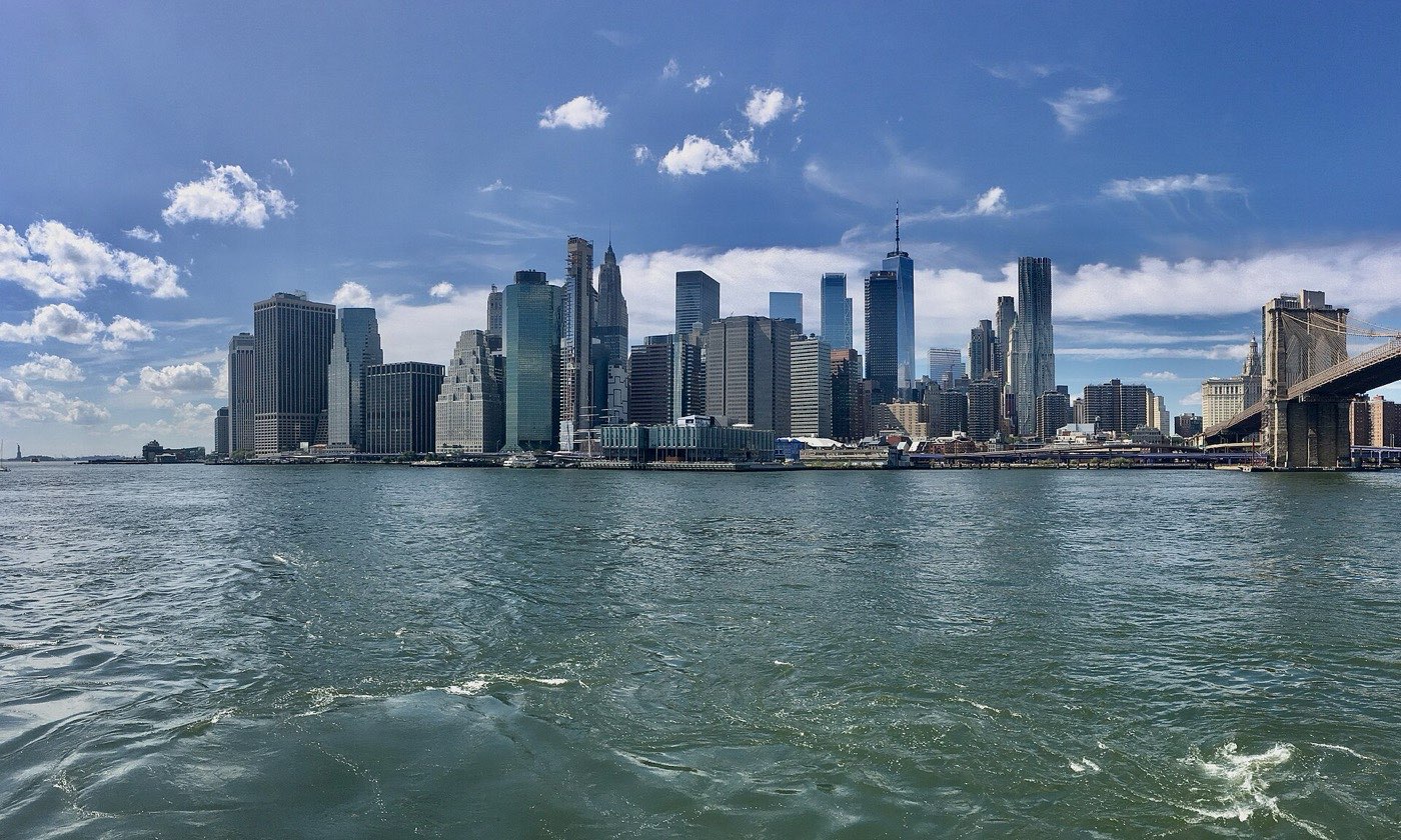 The Lower Manhattan skyline seen across the East River, with One World Trade Center at the centre and the Brooklyn Bridge at the right edge
